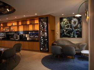 a bar with chairs and a counter with wine bottles at Mercure Paris Opera Garnier Hôtel & Spa in Paris