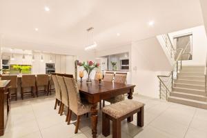 a dining room and kitchen with a wooden table and chairs at Tenos On Calypso 12 in Langebaan