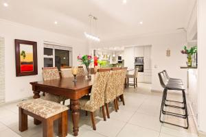 a dining room and kitchen with a wooden table and chairs at Tenos On Calypso 12 in Langebaan