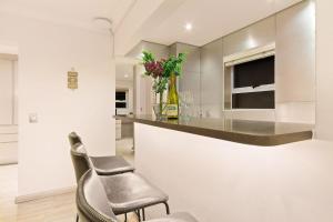 a kitchen with a counter and two chairs at Tenos On Calypso 12 in Langebaan +46 photos