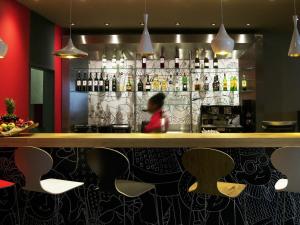 a person sitting at a bar in a restaurant at Hotel ibis Lisboa Saldanha in Lisbon