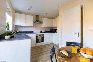 una cucina con tavolo in legno e arance di Eskdale House a Harwell