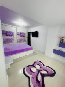 a bedroom with a purple bed and a purple rug at Apartament 2 camere in Bucharest