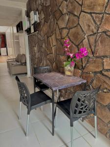 a dining table and chairs with a stone wall at Oásis a 1km Parque COP30 in Belém +18 photos