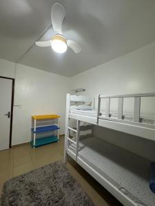 a bedroom with two bunk beds and a ceiling fan at Oásis a 1km Parque COP30 in Belém