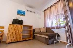 a room with a bed and a tv and a window at Бунгала Гнездото Bungalows The Nest Lozenets 2 in Lozenets