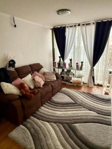 Una sala de estar con un sofá marrón con una alfombra grande. en Antofagasta Centro 2 habitaciones, en Antofagasta