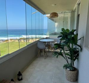 a balcony with a table and a view of the ocean at Apartamento primera linea El Tabo in El Tabo