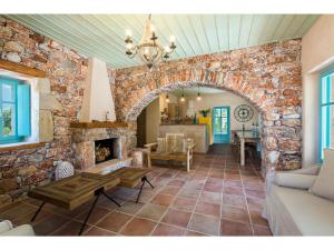 a living room with a stone wall and a fireplace at Pandora in Pyrgos Dirou