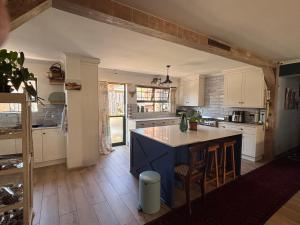 a kitchen with white cabinets and a blue island at Vintage Tide in Cape Town +4 photos