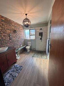 a bathroom with a sink and a toilet and a window at Vintage Tide in Cape Town