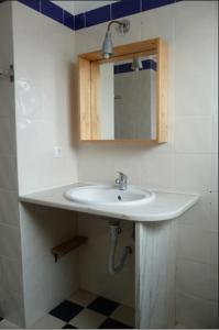 Un baño con un lavabo blanco y un espejo. en Ethic Surf House, en Ferrel