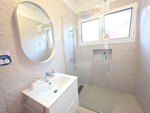 a white bathroom with a sink and a mirror at RODRIGUES ViLLA in Funchal +38 photos