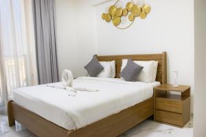 a bedroom with a large bed with white sheets at Marina Retreat Stylish One Bedroom by Hala Homes in Ras al Khaimah +25 photos