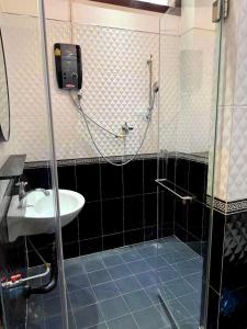 a bathroom with a sink and a glass shower at ZHOUhao HOTEL in Luang Prabang