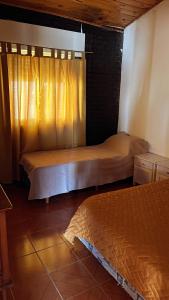 Un dormitorio con dos camas y una ventana con cortinas. en Bella Casa La Costa, en Santa Teresita 6 fotos más