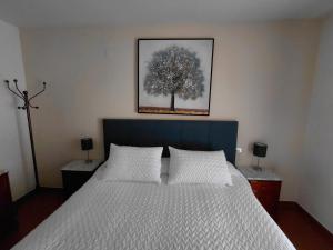 a bedroom with a bed with a tree picture on the wall at Apartamento para 6 personas en Barbastro in Barbastro