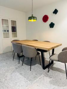 ein Esstisch mit Stühlen und einer roten Rose an der Wand in der Unterkunft Misericórdia Garden Homes in Vila do Conde