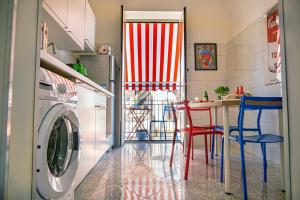 a kitchen with a washing machine and a table with chairs at Zietta's Pop House in Naples