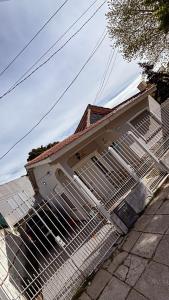 una casa con una valla metálica al costado en Bella Casa La Costa, en Santa Teresita