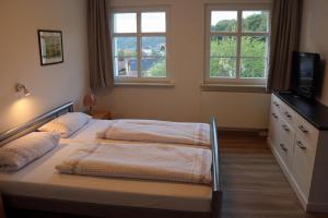a bedroom with two beds and two windows at Ferienwohnung im Kasperhaus in Hohnstein