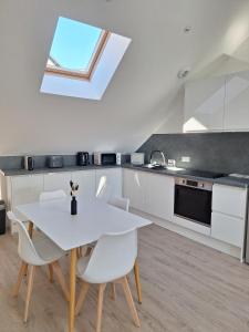 een keuken met een witte tafel en witte stoelen bij AquaLodge Harmonia in Aix-les-Bains +2 foto's