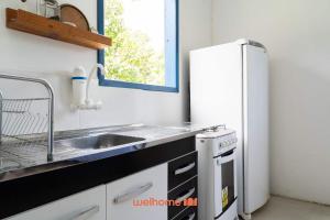 a kitchen with a sink and a refrigerator at Kitnet em Aldeia Velha com piscina e churrasqueira in Silva Jardim