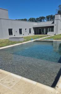 a swimming pool in front of a house at Hermosa Casa De Campo en Mercedes in Mercedes
