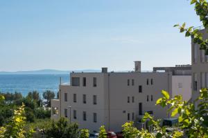 a white building with the ocean in the background at Luxury Rooms Near the Beach1 in Split