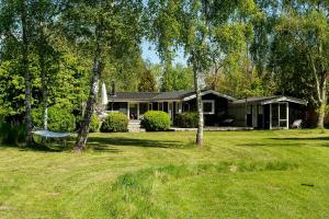 a house with a hammock in front of a yard at Sommerhus Med Udsigt Over Avnø Fjord in Vordingborg