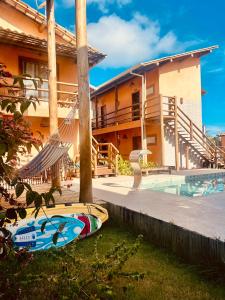 una casa con piscina e tavola da surf in giardino di Pousada Vila dos Corais - Taipu de Fora a Barra Grande
