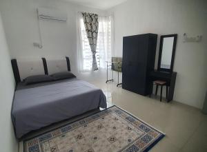 a bedroom with a bed and a mirror and a rug at Aristar D'Sejahtera Homestay 4 mu5lim in Bandar  Pusat Jengka