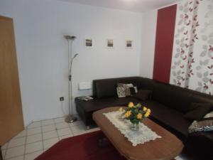 a living room with a couch and a table with flowers on it at Busche RE03 in Sögel