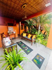 un patio con un divano, sedie e tappeti di Pousada Vila dos Corais - Taipu de Fora a Barra Grande Altre 24 foto
