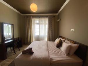 a bedroom with a large white bed with a piano at Seventh Heaven Villa in Hakgala