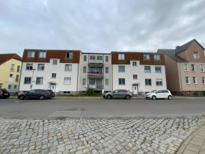 a parking lot with cars parked in front of a building at Schönes Appartement in Neubrandenburg