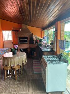 a kitchen with a stove and a table in it at Chácara São Marcos in Ibiúna +2 photos
