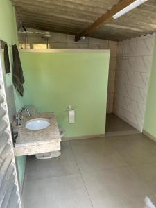 a bathroom with a sink and a green wall at Chácara São Marcos in Ibiúna