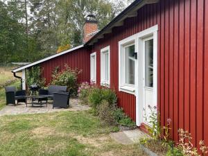 a red house with a table and chairs outside at Ådalsvägenhus in Fågelfors
