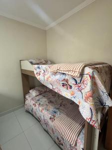 Apartamento Praia Grande caiçara في برايا جراندي: غرفة نوم مع سريرين بطابقين وملاءات +5 صور