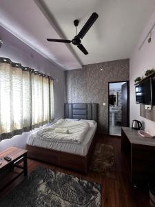 a bedroom with a bed and a ceiling fan at Hare Rama Guest House in Dehradun
