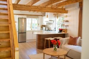 a kitchen and living room with a couch and a table at Sunset Stays Lavender Cottage in Cape Town