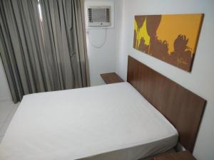 a bedroom with a bed and a window with a air conditioner at Boulevard Suite in Caldas Novas