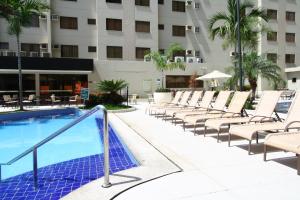 a swimming pool with lounge chairs and a hotel at Boulevard Suite in Caldas Novas