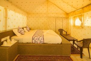 Un dormitorio con una cama en una tienda de campaña. en Sam Dunes desert Safari Camp, en Jaisalmer
