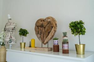 a wooden heart on a shelf with potted plants at EG Rechts große 3-Zimmer City Wohnung nähe Salzburg in Freilassing +11 photos