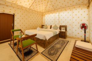 a bedroom with a bed and a chair in a room at Camp Inn Jaisalmer Resort in Jaisalmer +67 photos
