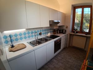 a kitchen with white cabinets and a sink at BotanicaSuiteTorino in Baldissero Torinese +19 photos