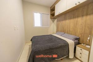 une chambre avec un lit et un mur en bois dans l'établissement Apartamento na Praia Grande a 500m Praia do Forte, à Praia Grande