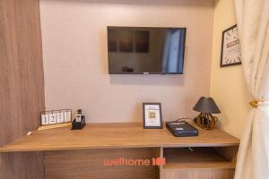 une pièce avec une télévision sur un mur avec un bureau dans l'établissement Apartamento na Praia Grande a 500m Praia do Forte, à Praia Grande